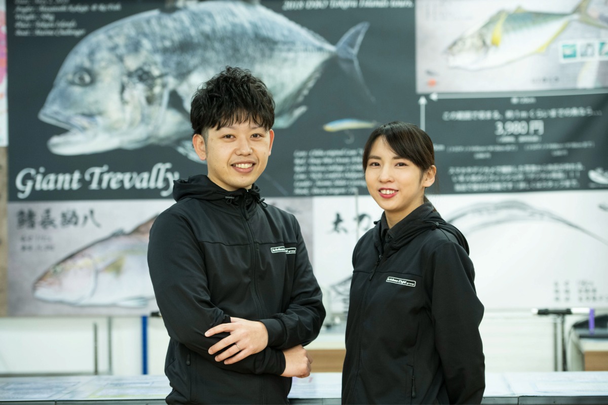 店舗の売り場づくりでPOPやレイアウトのアイデアを出し合う先輩と後輩スタッフ